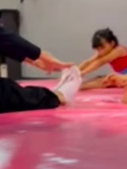 Niñas trabajando flexibilidad sobre la colchoneta del estudio.